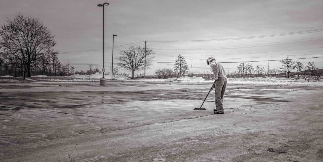 Person sweeping a parking lot